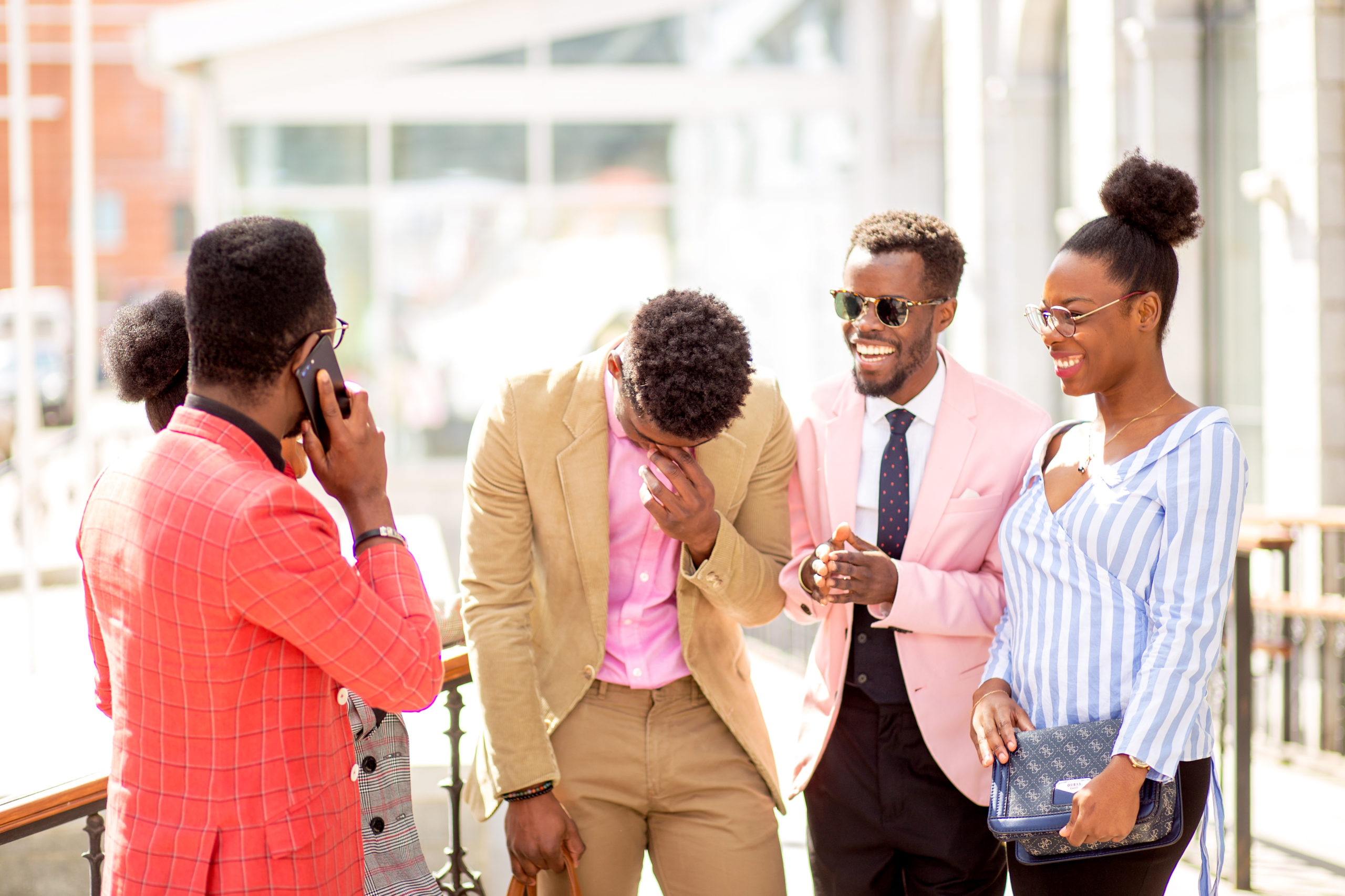 Business people standing next to a classic office building and laughing